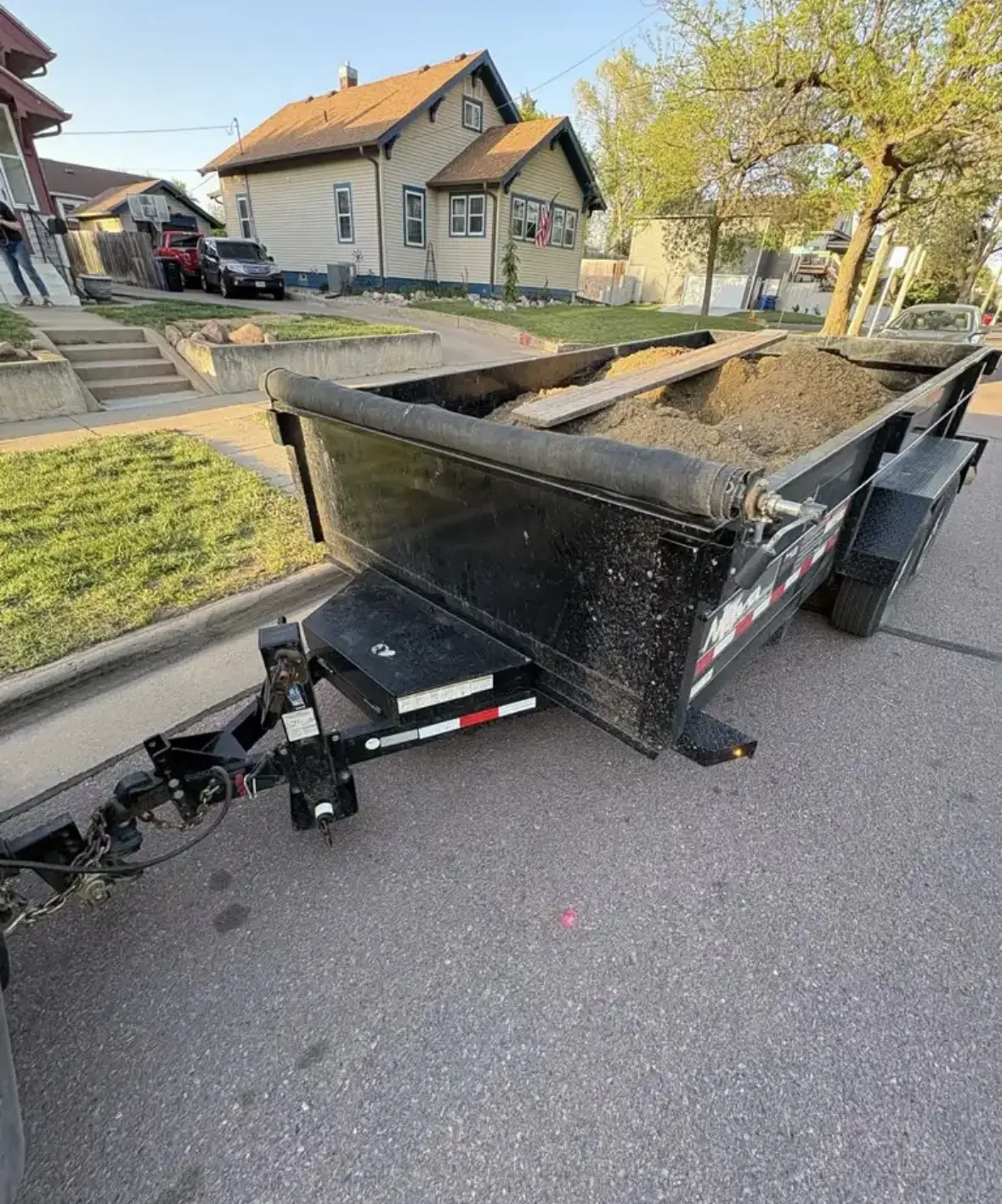 Dump trailer fully loaded with soil and landscaping debris
