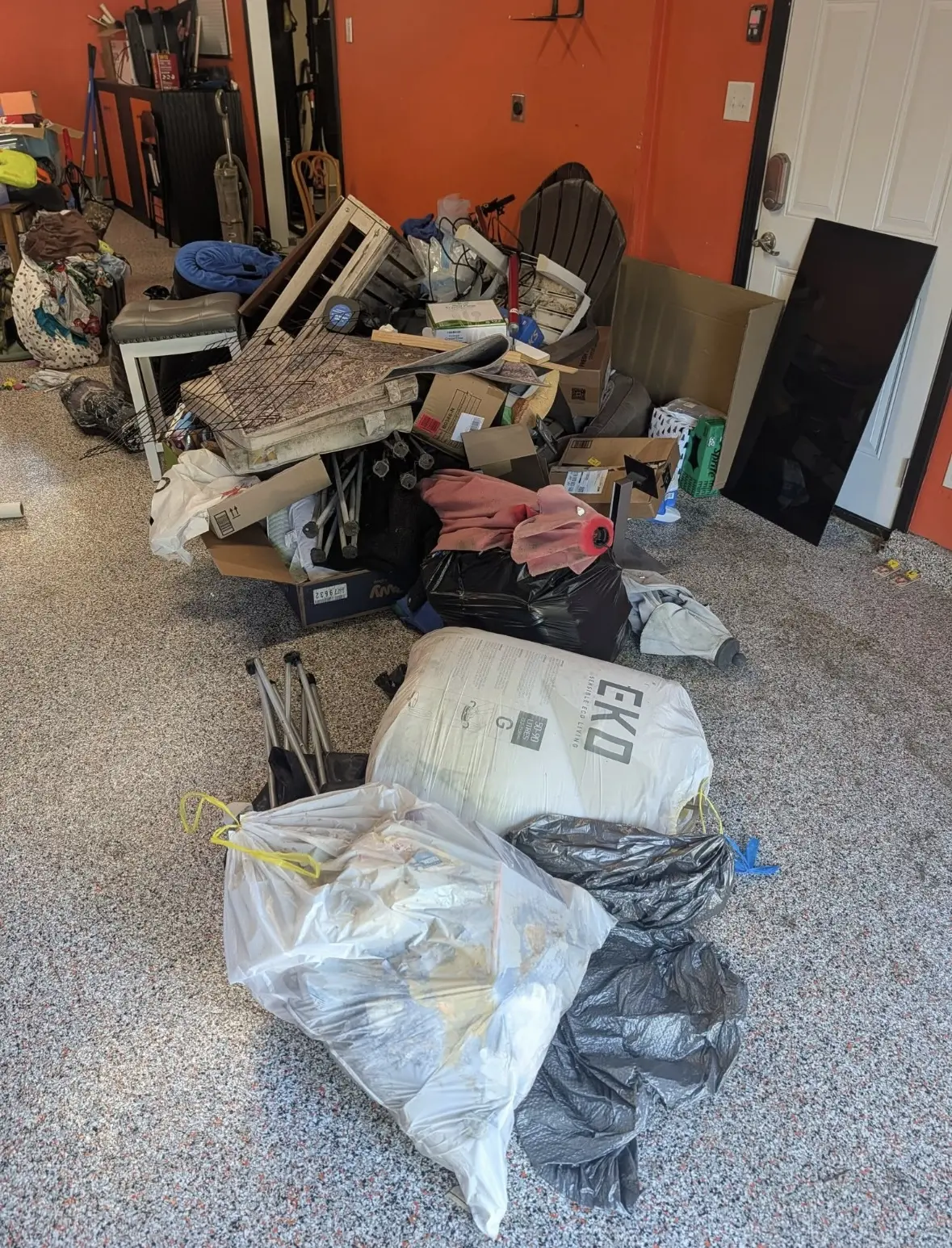 Garage filled with bags, boxes, and household junk before cleanout